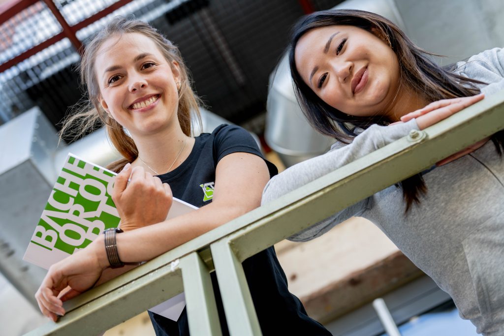 Zwei Studentinnen schauen vom Geländer runter